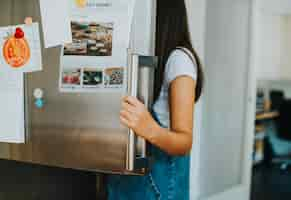 Foto gratuita chica recogiendo algo para comer de la nevera