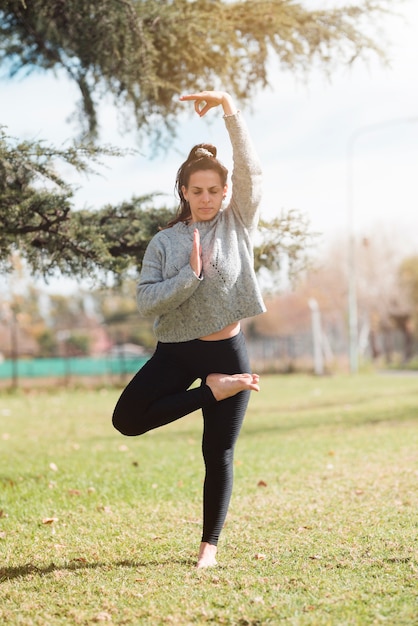 Chica relajada practicando yoga al aire libre