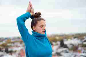 Foto gratuita chica relajada practicando yoga al aire libre