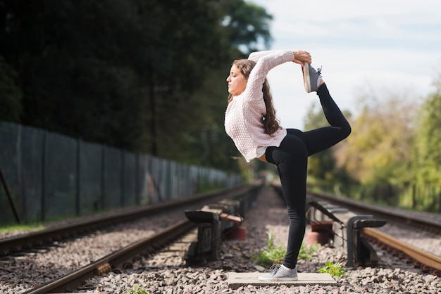 Chica relajada practicando yoga al aire libre