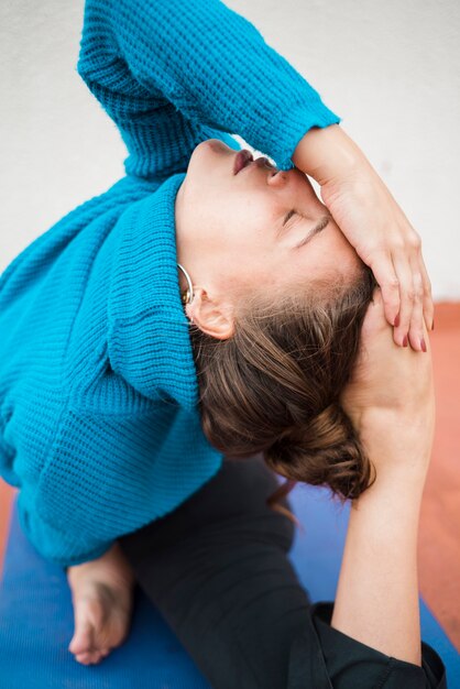 Chica relajada practicando yoga en casa