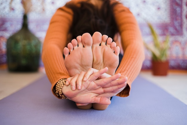 Chica relajada practicando yoga en casa