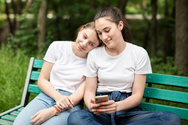 Chica revisando su teléfono con una amiga