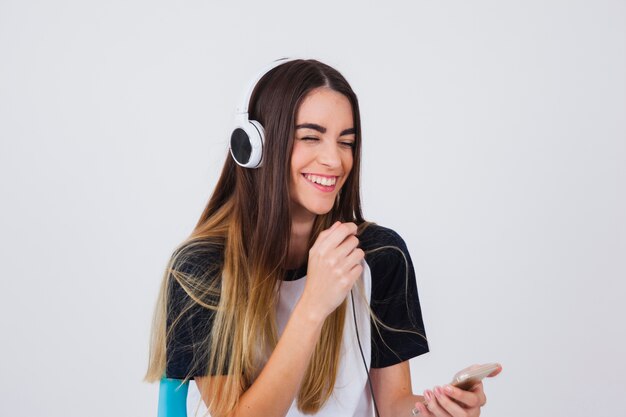 Chica riéndose con cascos de música