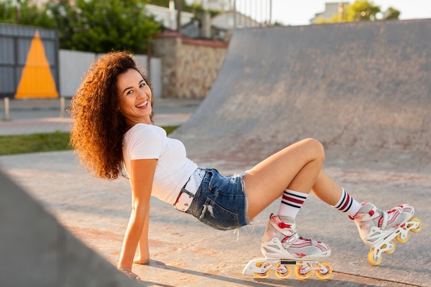 Foto gratuita chica rizada posando mientras usa patines