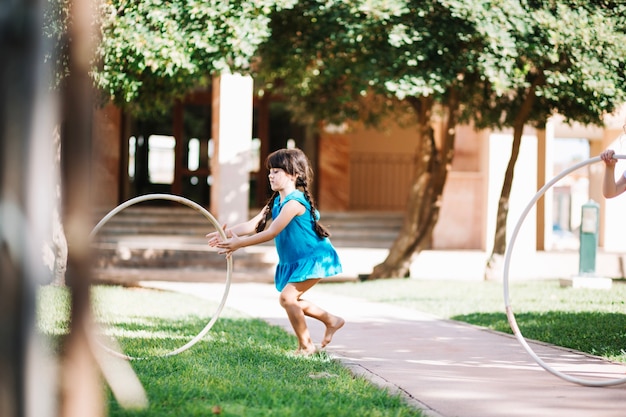 Chica rodando hula hoop en hierba