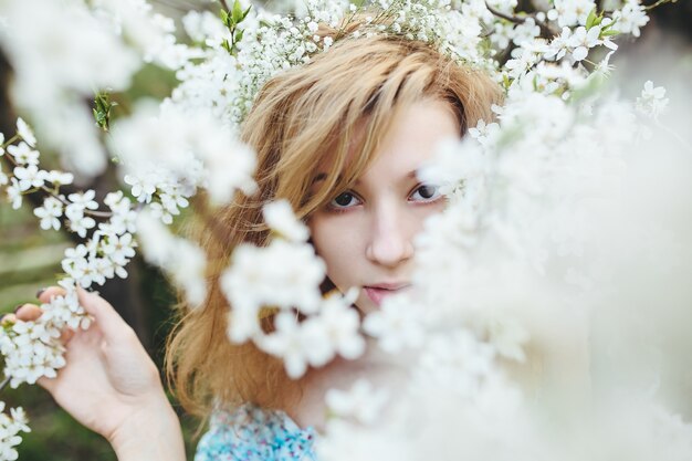 Chica rodeada de ramas en flor