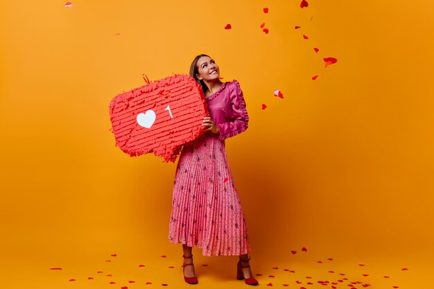 Chica romántica de ensueño de muy buen humor durante la sesión de fotos con grandes como en sus manos. modelo en blusa de moda con volante