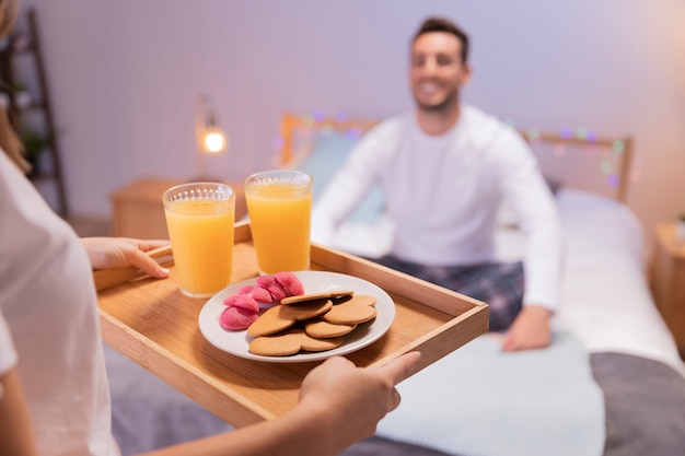 Chica romántica trae el desayuno a su esposo