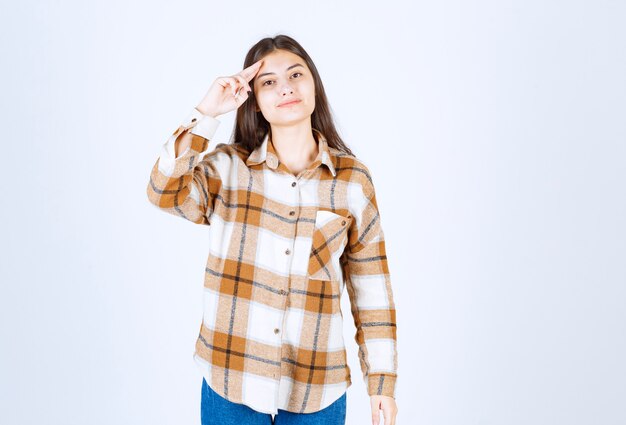 chica en ropa casual de pie en la pared blanca.