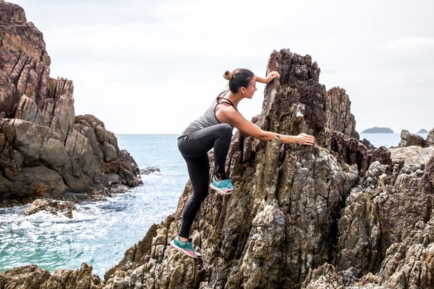 La chica en ropa deportiva en las rocas