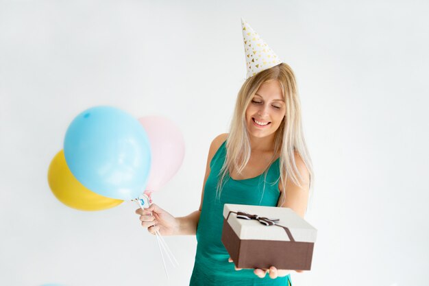 Chica rubia alegre en sombrero de cumpleaños