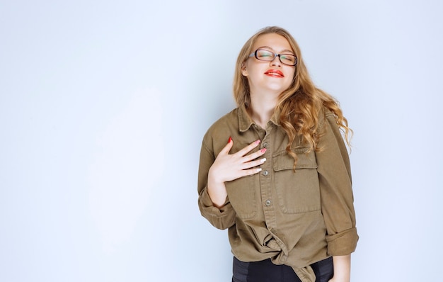 Foto gratuita chica rubia apuntando a sí misma y se ve positiva.