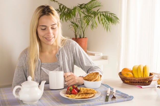 Foto gratuita chica rubia desayunando