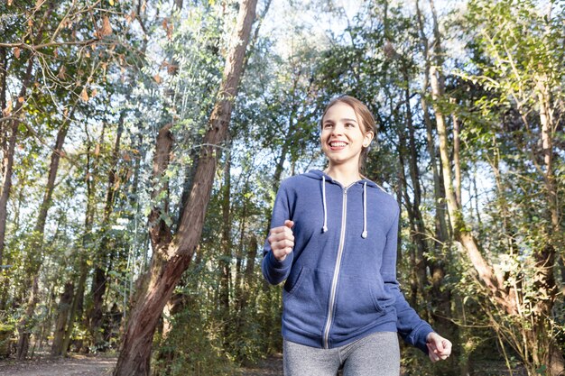 Chica rubia disfrutando mientras corre al aire libre