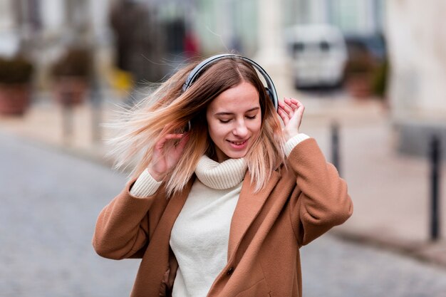 Chica rubia disfrutando de la música en los auriculares