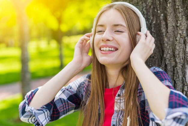 Chica rubia escuchando música con auriculares