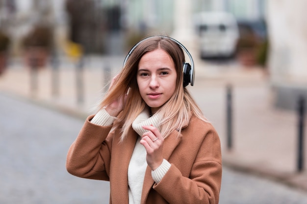 Chica rubia escuchando música con auriculares