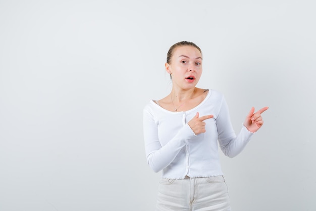 Chica rubia está mostrando el lado derecho sobre fondo blanco.