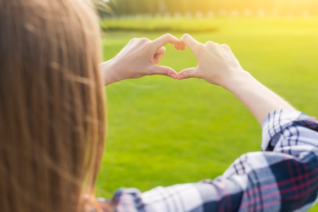 Foto gratuita chica rubia haciendo un corazón con sus manos