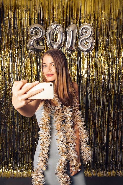 Chica rubia haciendo un selfie en celebración de año nuevo