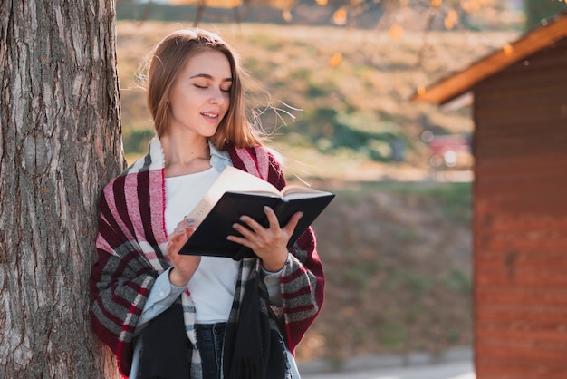 Chica rubia leyendo desde un cuaderno