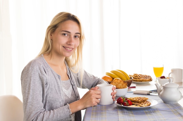 Chica rubia en mesa de desayuno