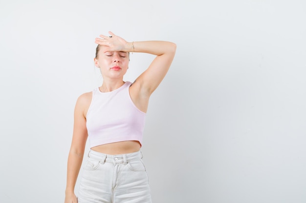 Foto gratuita chica rubia está mostrando su dolor de cabeza sobre fondo blanco.