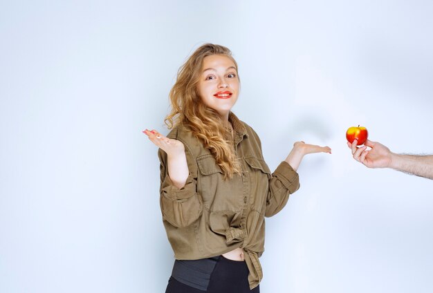 A la chica rubia se le ofrece una manzana roja o un melocotón.