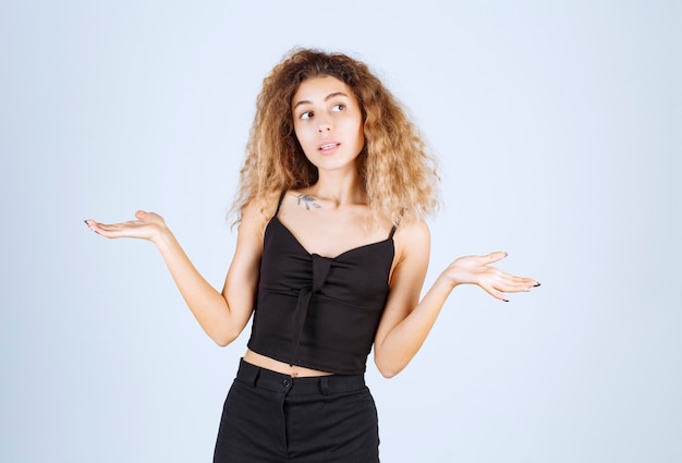 La chica rubia con pelos rizados parece confundida y perdida.