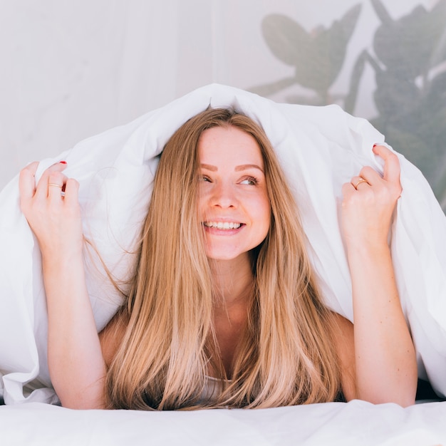 Chica rubia posando en la cama