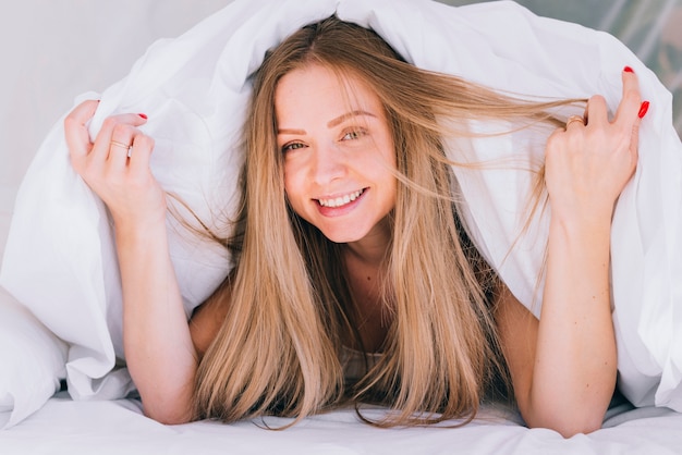 Chica rubia posando en la cama