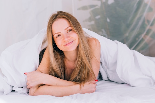 Chica rubia posando en la cama