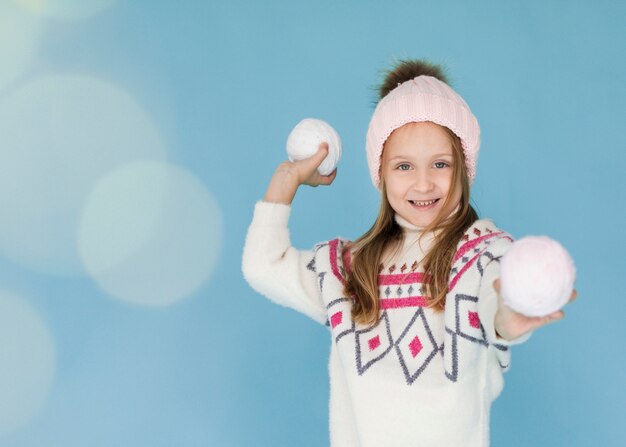 Chica rubia preparándose para lanzar una bola de nieve