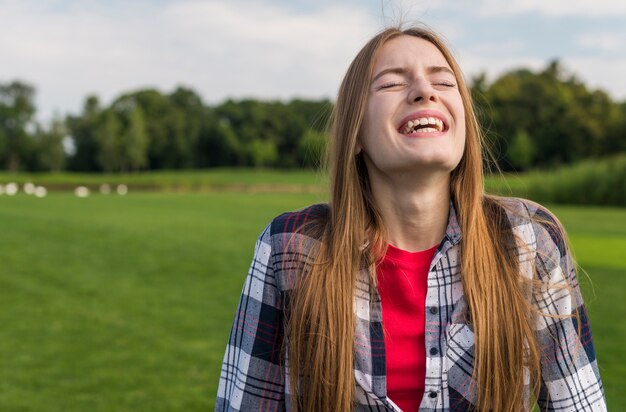 Chica rubia riendo con los ojos cerrados