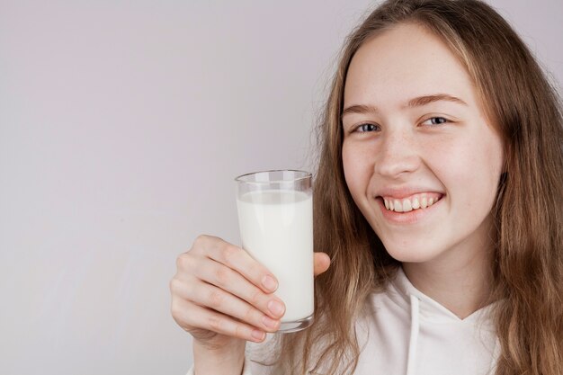 Chica rubia sosteniendo un vaso de leche