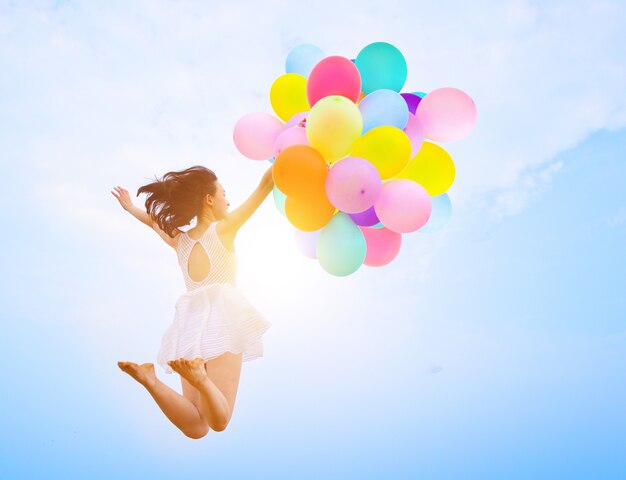 Chica saltando con globos