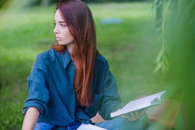 Chica sentada fuera de la celebración de libro