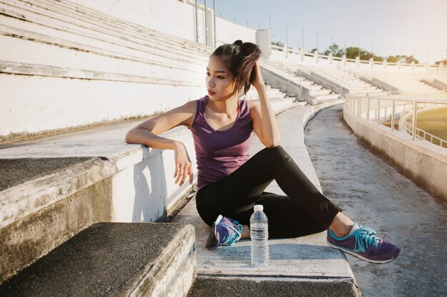 Chica sentada en la grada de un estadio