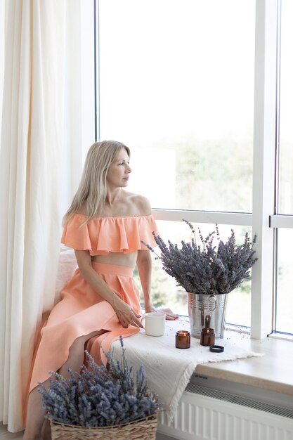 Chica sentada junto a la ventana Ramos de lavanda