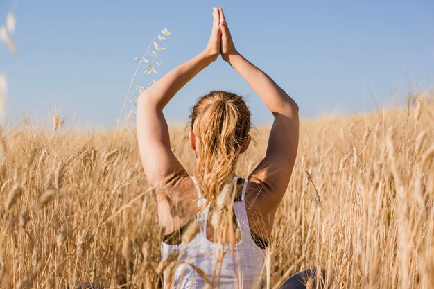 Chica sentada y meditando en la hierba