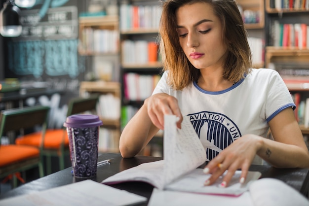 Chica sentada a la mesa en la biblioteca