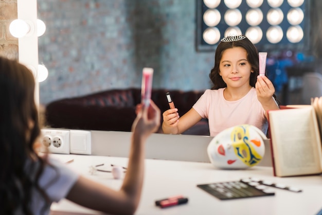 Chica sentada en la sala de maquillaje elegir cosméticos