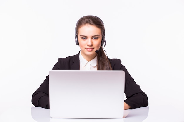 Chica de servicio al cliente joven con un auricular en su lugar de trabajo aislado en la pared blanca