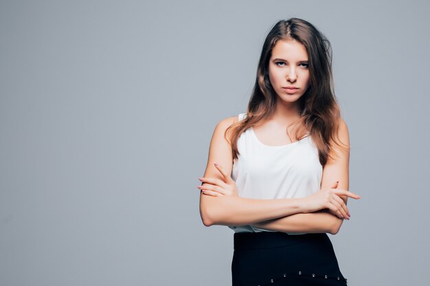 Chica sexy seria en vestido moderno de moda está posando en estudio aislado sobre fondo blanco