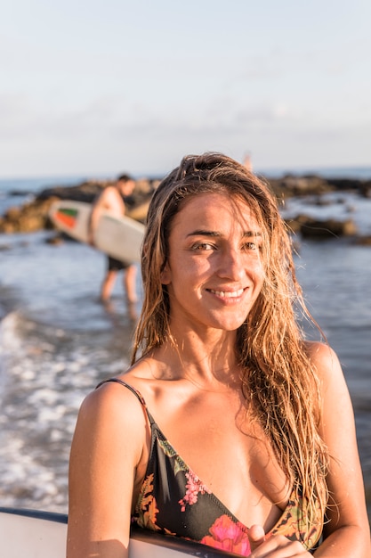 Chica sexy con tabla de surf en la playa