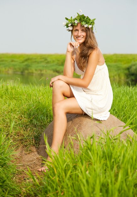 Chica se sienta en el campo de piedra