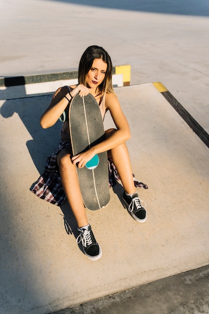 Chica skater sujetando tabla