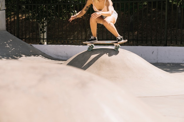 Chica skating sobre colina de hormigón