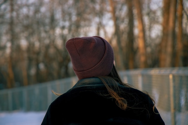 Chica con un sombrero de pie en el bosque durante el día